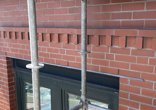 This image shows through wall flashing with weeps, but no end dams at the limits of the flashing. You can tell vertical end dams were not provided as the flashing ends in the middle of a brick unit not at a mortar joint.