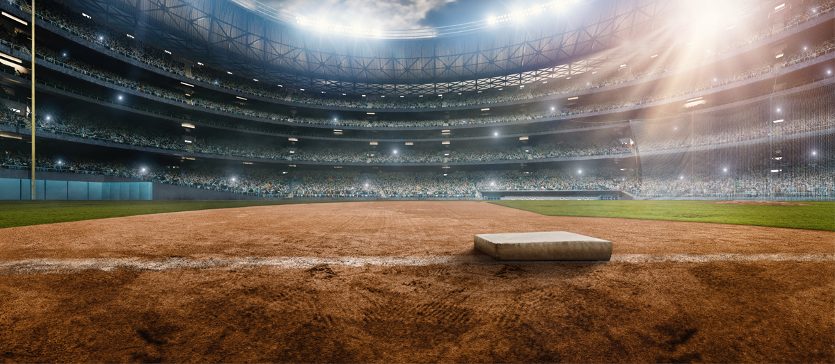Outdoor baseball stadium full of spectators under a stormy night sky. 